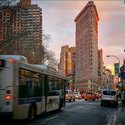 View of city street against cloudy sky