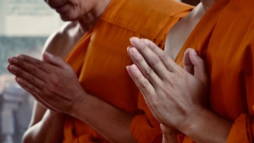 Close-up of hands holding cross at temple