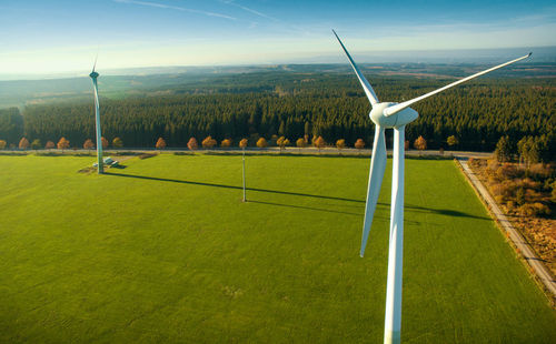 Windmill on grass against sky