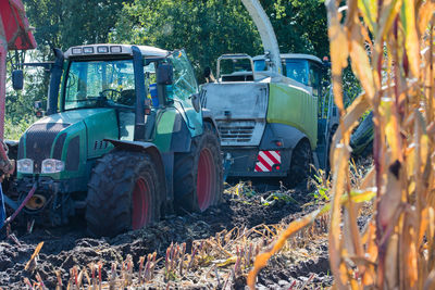 Tractors on field against tree