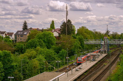 Train on railroad tracks in city against sky