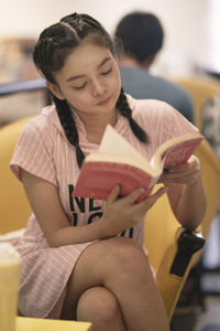 Low section of a woman sitting on book
