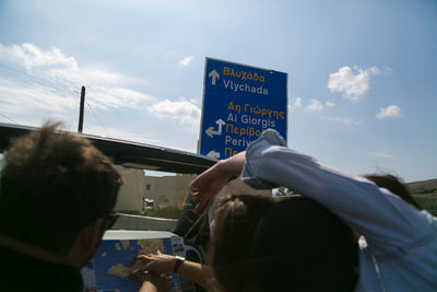 Man hand with text against sky