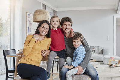 Portrait of happy family with two kids at home