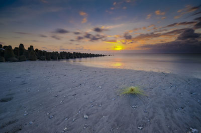 Scenic view of beach against sky during sunset