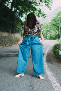 Full length of woman standing on road