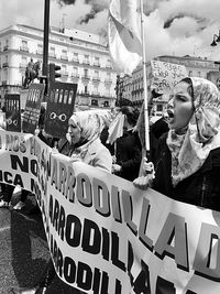 People holding banners while protesting in city street