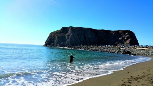 Man fishing in sea at beach