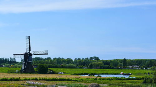 Windmill on field against sky