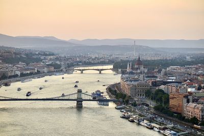 High angle view of city at river during sunset