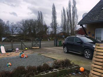 Toy car on field by building against sky