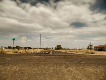 Empty road against cloudy sky