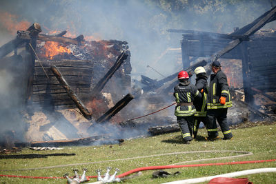 Rear view of people standing against fire