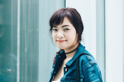 Portrait of smiling young woman wearing denim jacket