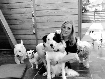 Portrait of woman with dogs against fence