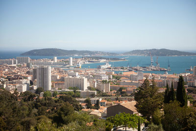 High angle view of townscape by sea against sky