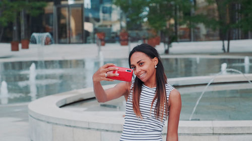 Young woman drinking water in city