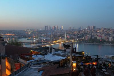 High angle view of city lit up against sky