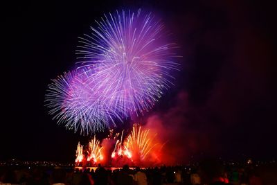 Low angle view of firework display at night