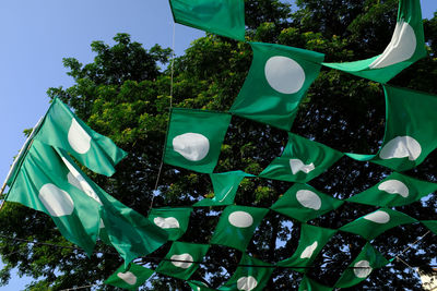 Low angle view of flags hanging against trees