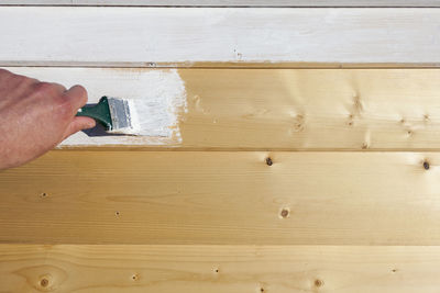 Close-up of hand painting wood 