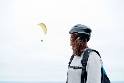 Rear view of woman with umbrella against sky