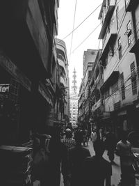 People walking on street amidst buildings in city