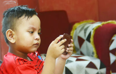 Close-up portrait of boy using cell phone