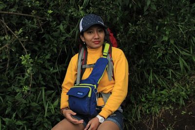 Portrait of teenage girl sitting on plants