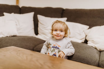 Cute girl by sofa at home