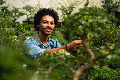 Portrait of smiling young man against plants