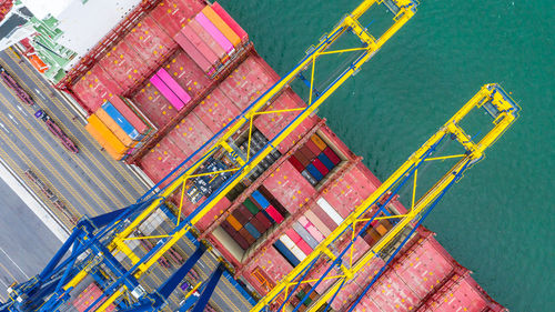 Directly above shot of crane and cargo container by lake