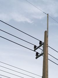 Low angle view of electricity pylon against sky