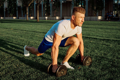 Side view of man exercising on field