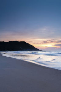 Scenic view of beach against sky during sunset