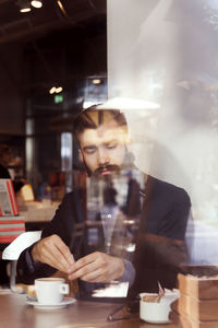 Portrait of young woman using mobile phone at cafe