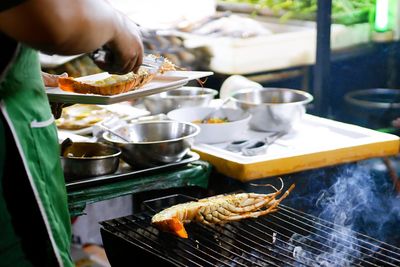 Close-up of preparing food on barbecue grill