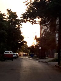 Cars on street in city at sunset