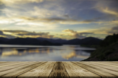 Pier over lake against sky during sunset