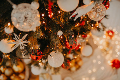 Abstract christmas and new year tree decor in red and gold colors close-up, with garlands and lights