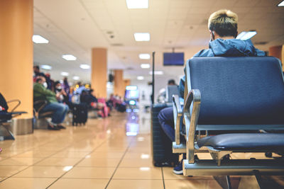 Empty chairs in the departure hall of the airport. unrecognizable people blurred.