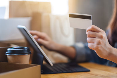 A woman using tablet pc and credit card for online shopping with postal parcel box 