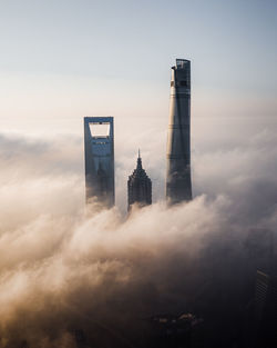 Buildings in city against cloudy sky