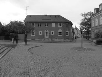 Houses by street in town against sky