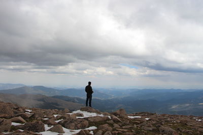 Rear view of man standing on rock formation