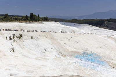 View of pamukkale natural limestone pools, crowd of tourists. turkey.
