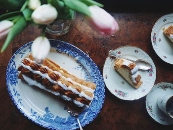 High angle view of cream cake in plates on table