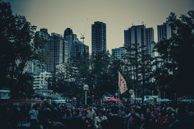 People on street amidst buildings in city