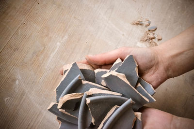 High angle view of person hand holding wood