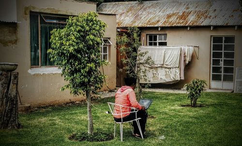 Rear view of house in yard against building